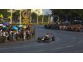 Red Bull's Mark Webber drives past Thai fans
